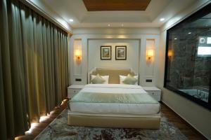 una camera con un grande letto e una televisione di Casa De Bello, Nainital, Near Kainchi Dham a Nainital