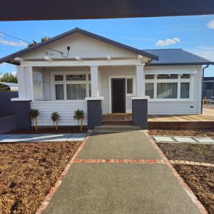 a white house with a pathway in front of it at Che Bella in Martinborough