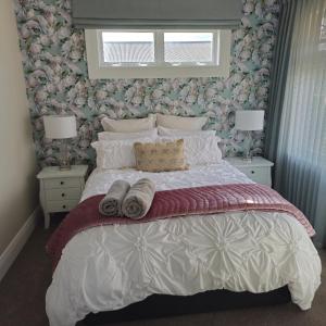 a bedroom with a large bed with two nightstands and two lamps at Che Bella in Martinborough