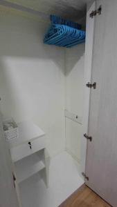 a white room with a closet with a blue umbrella at Lumpini Prachachaeun Great condo near Lumpini Park in Ban Bang Khen (1)