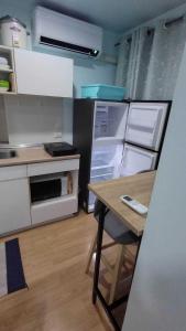 een keuken met een open koelkast en een tafel bij Lumpini Prachachaeun Great condo near Lumpini Park in Ban Bang Khen (1)