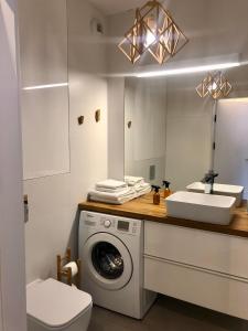 een badkamer met een wasmachine en een wastafel bij Cosy apartment green&quiet Ursynów in Warschau