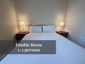 1 dormitorio con 1 cama blanca y 2 lámparas en Helen's Hotel en Londres