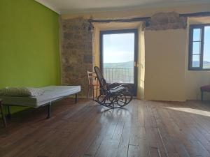 a room with a bench and a bed and a window at Albergue de peregrinos Casa Nostra in Castrojeriz