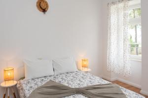 sypialnia z łóżkiem z 2 lampami i oknem w obiekcie Apartments house Pinezic w mieście Malinska