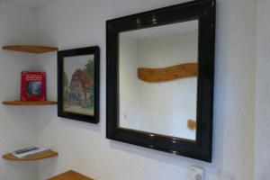 a mirror on a wall with a wooden stick at Landleben in Fritzlar