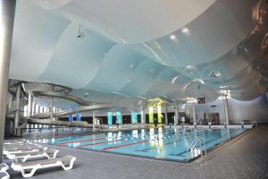 Appartement de charme + parking centre-ville Arras في أراس: مسبح في مبنى بسقف كبير