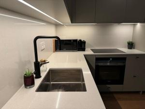 a kitchen with a sink and a microwave at Elegant lägenhet i Professorstaden in Lund