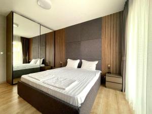 a bedroom with a large bed with a large mirror at Open Sea Panorama Residence in Obzor