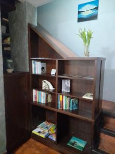 una estantería de madera con libros. en Claustro Home Casco Histórico Córdoba, en Córdoba