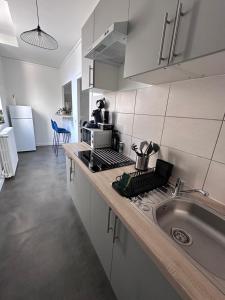 a kitchen with a sink and a stove top oven at L évasion centre ville famille in Auxerre