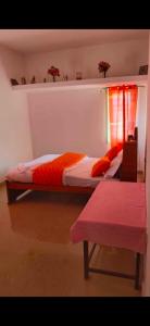 twee bedden in een slaapkamer met een raam en een bank bij HOME STAY PARADISE in Pūrnānkuppam