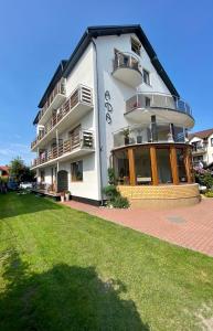 a large white building with a lawn in front of it at Willa Ada in Karwia