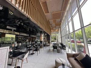 ein Restaurant mit Tischen, Stühlen und Fenstern in der Unterkunft S42 Wyndham Garden Sukhumvit BTS Ekkamai Gym Swim in Bangkok