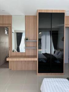 a bedroom with a bed and a large mirror at Tarn’s pool villa Rawai in Ban Saiyuan (1)