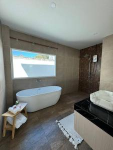 a large bathroom with a tub and a sink at Tarn’s pool villa Rawai in Ban Saiyuan (1)