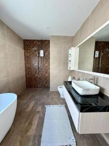 a bathroom with a sink and a tub and a toilet at Tarn’s pool villa Rawai in Ban Saiyuan (1)
