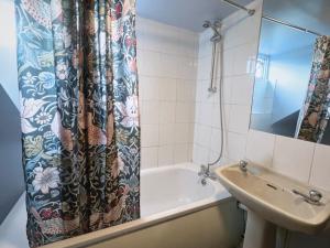 a bathroom with a shower curtain and a sink at Helen's Hotel in London