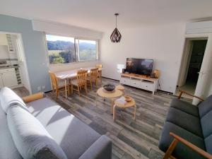 een woonkamer met een bank en een tafel bij T3 De Charme - avec clim, parking et piscine in Le Lavandou