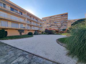 een lege parkeerplaats voor een gebouw bij T3 De Charme - avec clim, parking et piscine in Le Lavandou