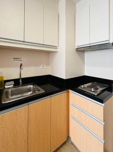 a kitchen with white cabinets and a sink at 2* * Contemporary Comfort in Iloilo City