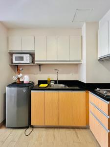 a kitchen with white cabinets and a sink at 2* * Contemporary Comfort in Iloilo City