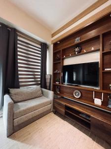 a living room with a large television and a couch at 1 Urban Elegance in Iloilo City