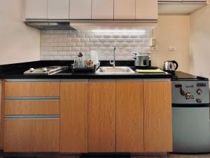 a kitchen with a sink and a refrigerator at 1 Urban Elegance in Iloilo City +11 photos