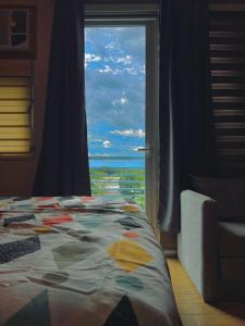 a bedroom with a bed with a view of the ocean at 1 Urban Elegance in Iloilo City