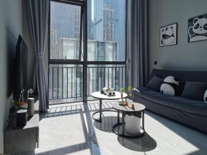 a living room with a couch and a large window at Panda ZuoKe Besucher Apartment 熊猫坐客民宿 in Kunming