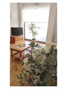 科米利亞斯的住宿－Pension Villa **，客厅配有桌子和盆栽植物