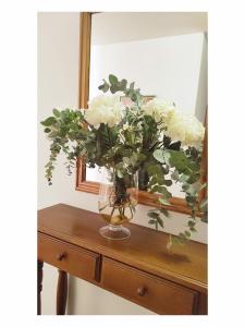 a vase filled with white flowers sitting on a table at Pension Villa ** in Comillas