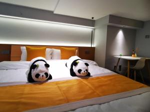 Cama ou camas em um quarto em Panda ZuoKe Besucher Apartment 熊猫坐客民宿