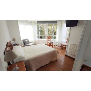 a bedroom with a bed and a table and chairs at Pension Villa ** in Comillas