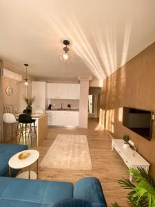 een woonkamer met een blauwe bank en een keuken bij Iris Luxury Apartaments in Mamaia