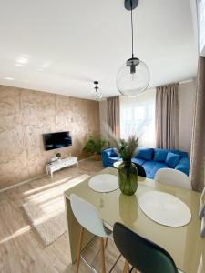a living room with a table and a blue couch at Iris Luxury Apartaments in Mamaia