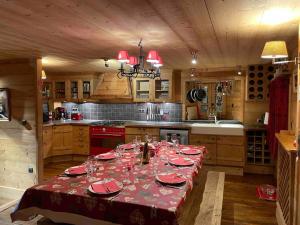 eine Küche mit einem Tisch und Weingläsern darauf in der Unterkunft Chalet 1728 - La Reculaz - 2 minutes from Val D'isere in Tignes