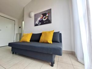 a blue couch with yellow pillows in a room at La casa di Laura in Seregno