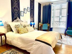 1 dormitorio con 1 cama grande y cortinas azules en Maison B, en Bergerac