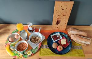 Petit nid en Alsace studio indépendant avec salle de douche privative في Buschwiller: طاولة مع صينية من الطعام وصحن من الخبز