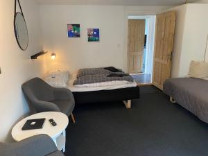 Habitación con 2 camas, sofá y silla en Siesta Vejle, en Vejle