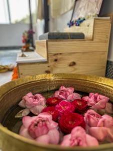 Ein Haufen rosa Rosen in einem hölzernen Eimer in der Unterkunft Leela Hatha in Rishikesh
