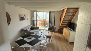 een kleine woonkamer met een tafel en een bank bij Bel Appartement Saint-Malo la Varde in Saint-Malo