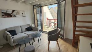een woonkamer met een bank en twee tafels bij Bel Appartement Saint-Malo la Varde in Saint-Malo