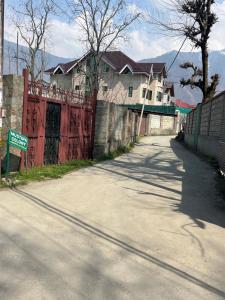 a house with a red fence on the side of a road at The Light House in Srinagar