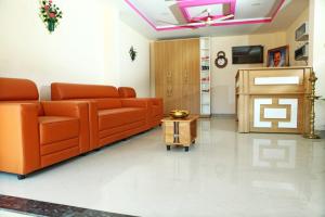 a living room with an orange couch and a table at Karamangattu Residency in Ramakkalmedu