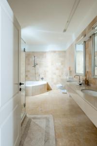 a bathroom with two sinks and a bath tub at BreezHouse P 61 in Ramat Gan