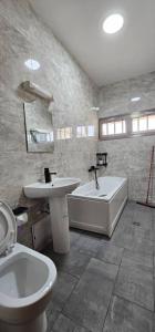 łazienka z umywalką, wanną i toaletą w obiekcie Résidence du goût w mieście Kribi