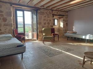 a room with a bed and a table and chairs at Albergue de peregrinos Casa Nostra in Castrojeriz