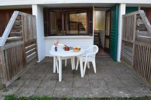 einen weißen Tisch und zwei Stühle auf einer Terrasse in der Unterkunft Résidence du Val de Villé in Albé